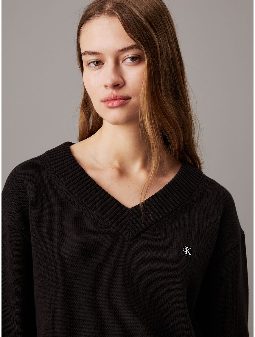 Saco negro tejido de pico con insignia de algodón