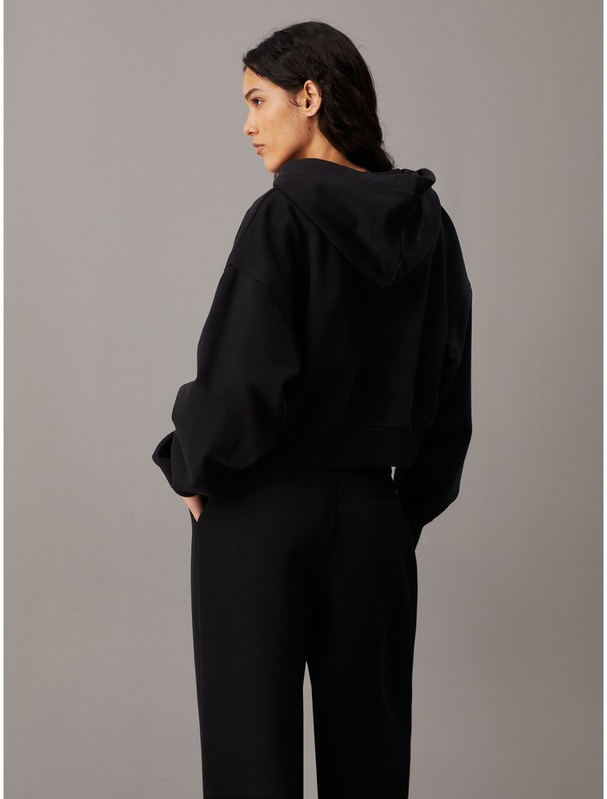 Buzo negro cropped con capota, cremallera y logo