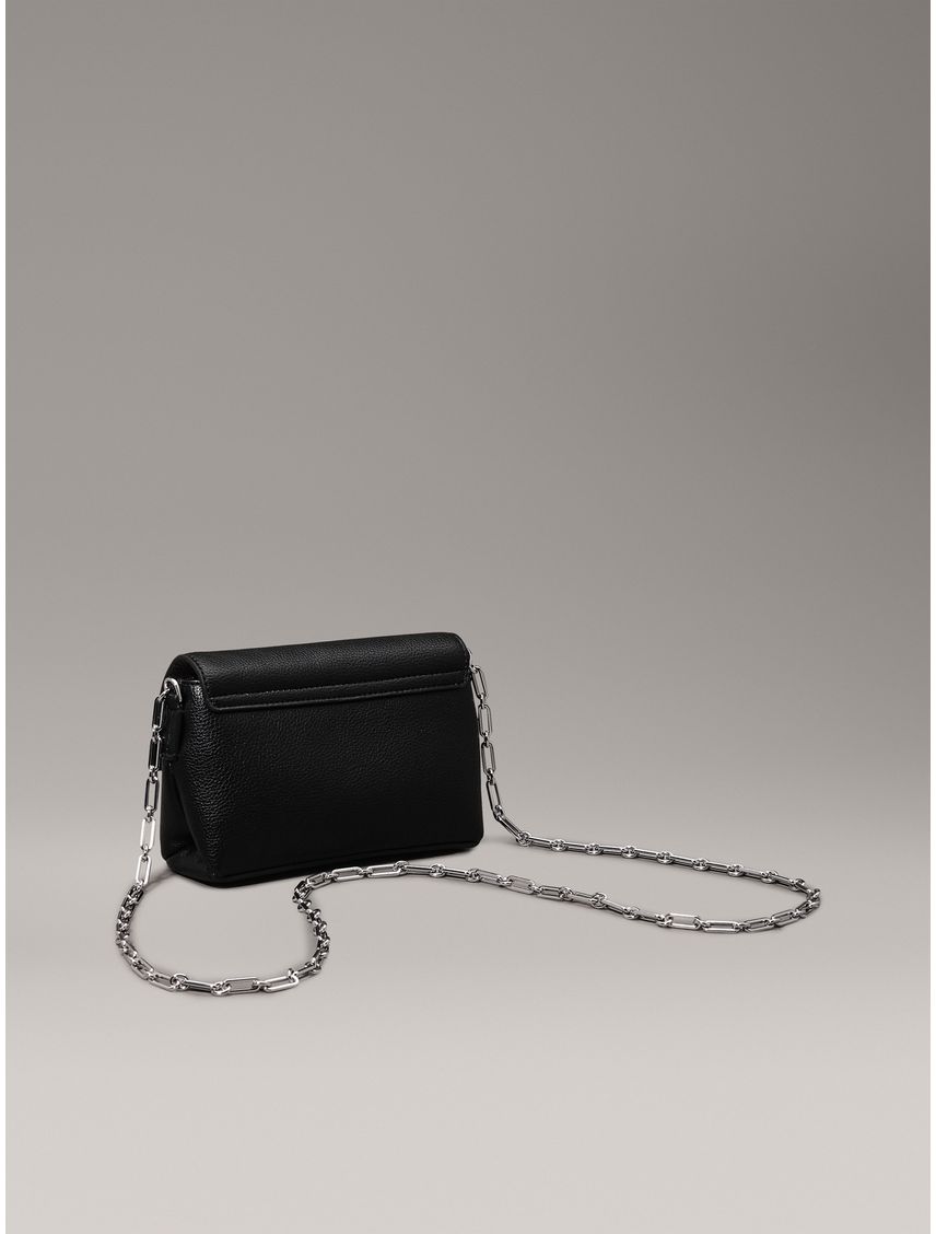 Bolso negro cruzado con placa y cadena